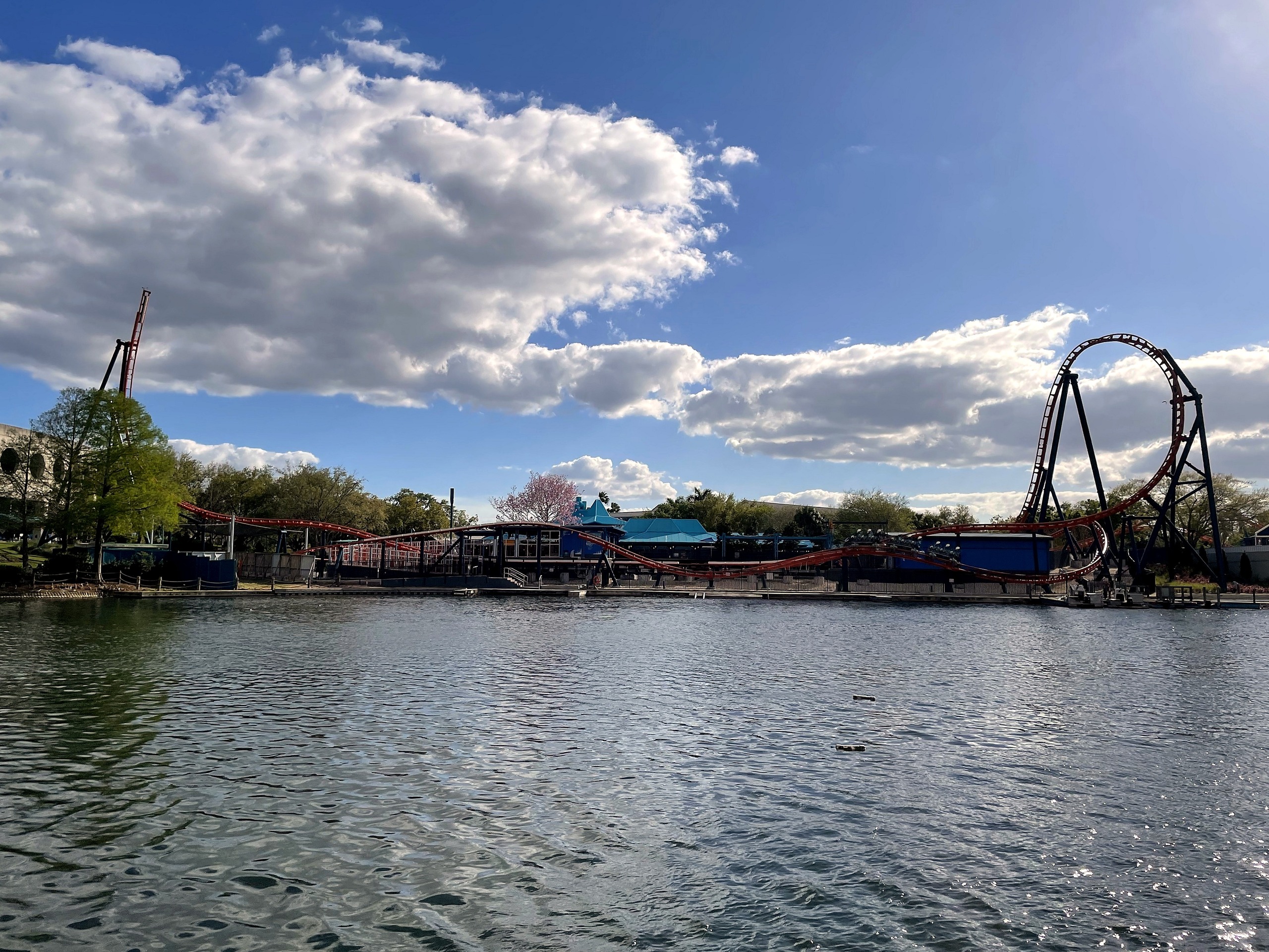 Ice Breaker's top hat and spike beyond the lake under a cloudy sky at SeaWorld Orlando, March 2021