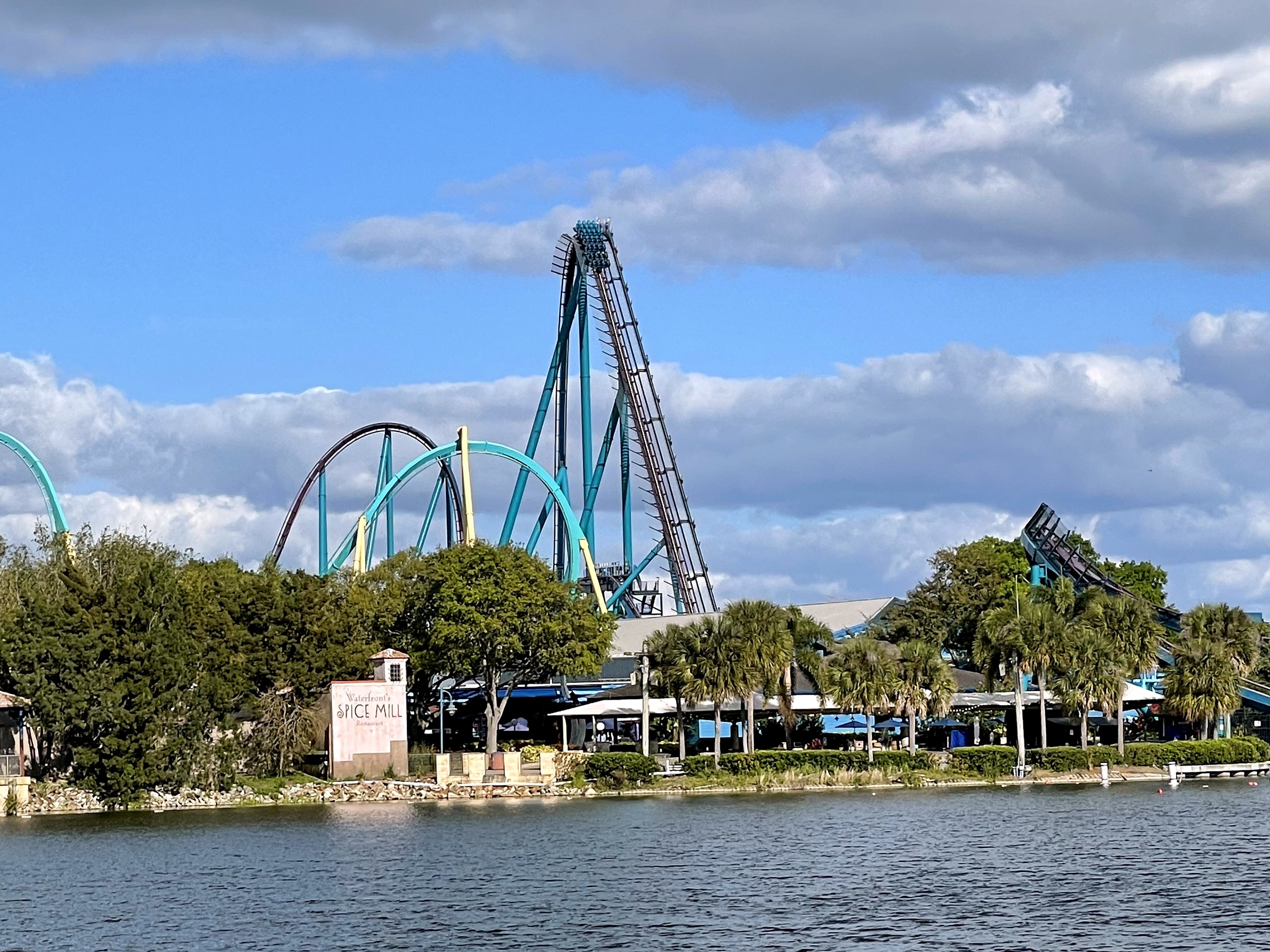 Mako's lift hill rising behind Kraken's teal loop across the lake at SeaWorld Orlando, March 2021