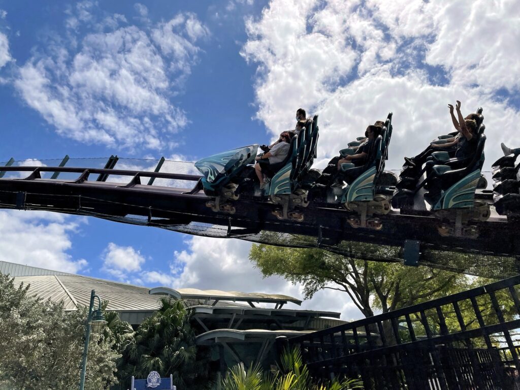 A Mako train with riders' arms raised passing directly overhead at SeaWorld Orlando, March 2021