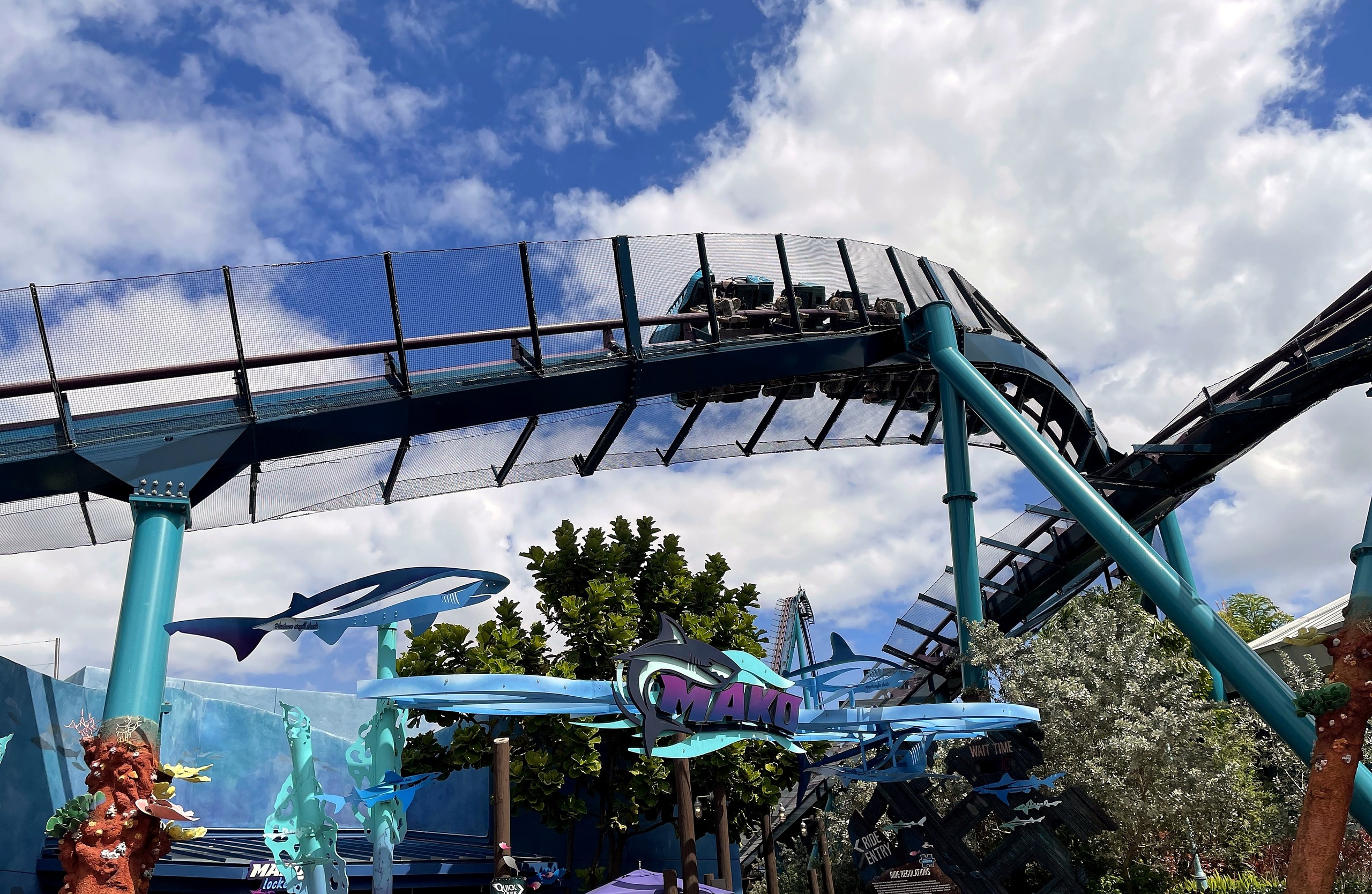 A Mako train passing over the entrance sign on the track at SeaWorld Orlando, March 2021