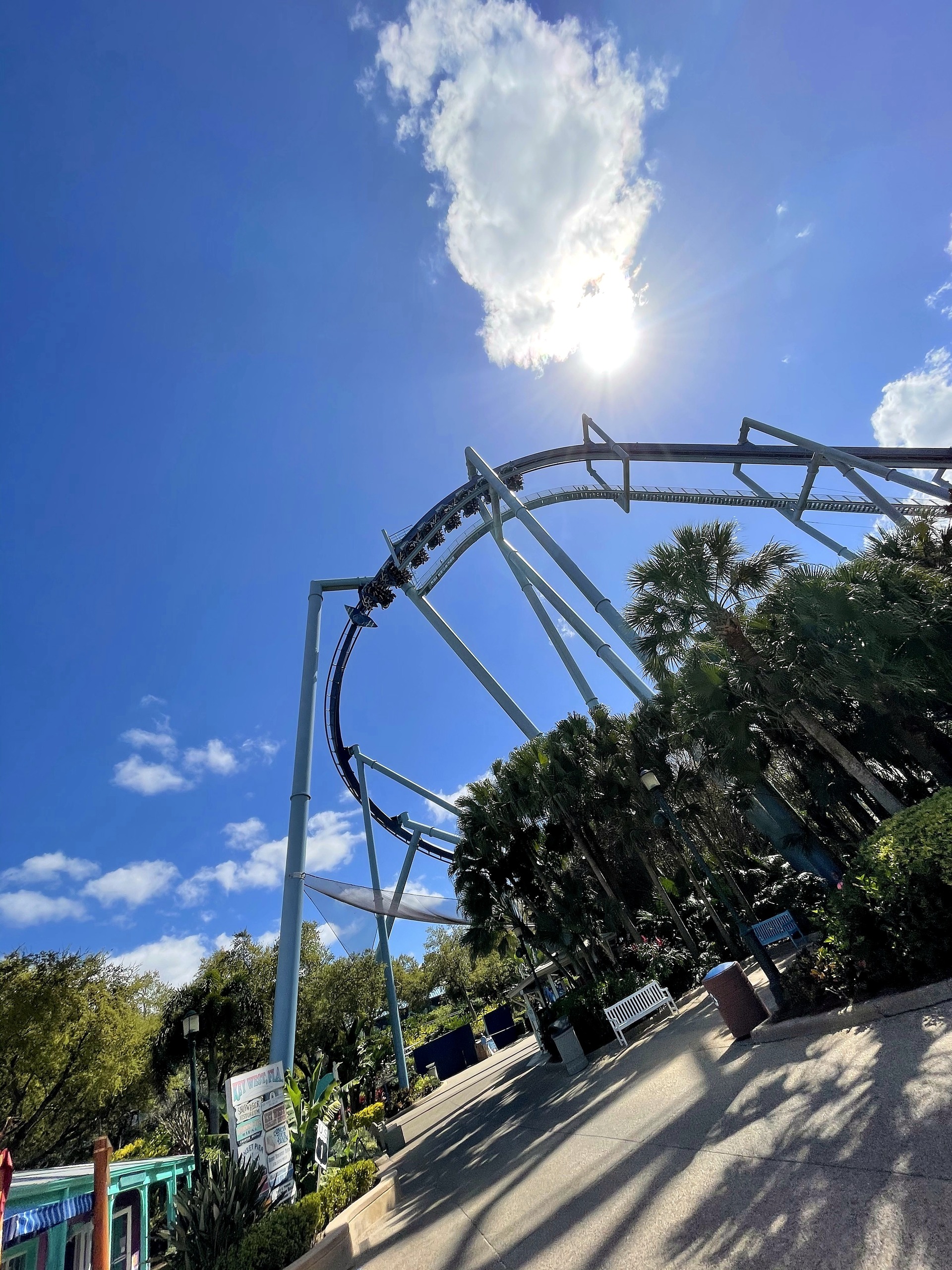 Manta's loop and supports above the midway path with the sun overhead at SeaWorld Orlando, March 2021
