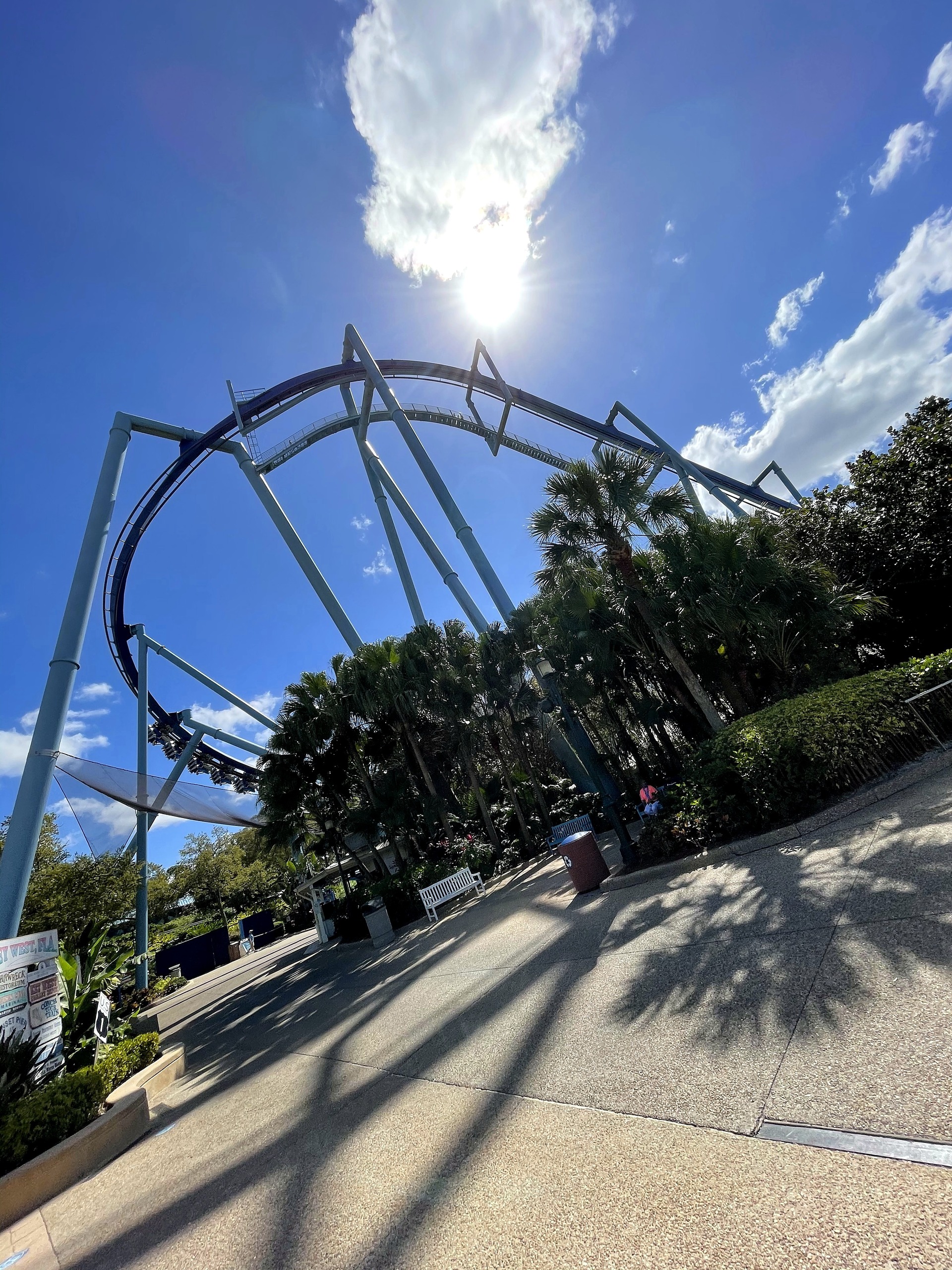 A Manta train in the loop above the walkway with the sun overhead at SeaWorld Orlando, March 2021