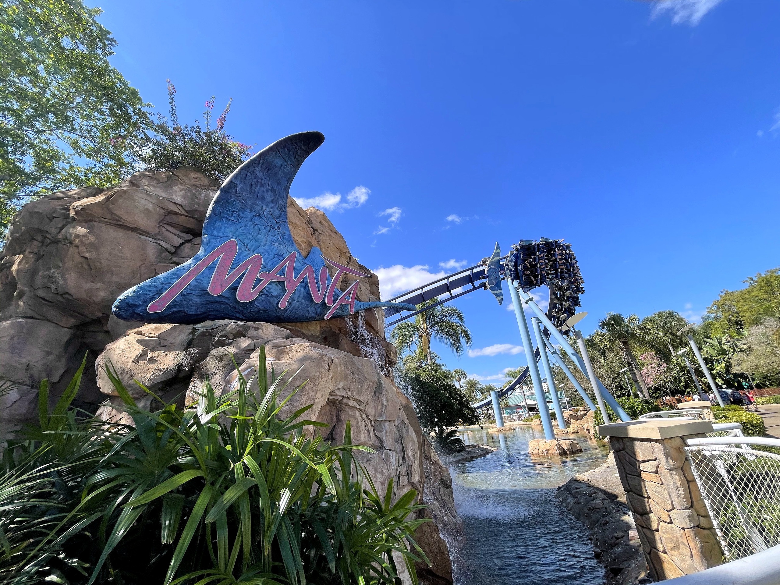 The Manta sign on the rocks with a train flying past on the track behind it at SeaWorld Orlando, March 2021