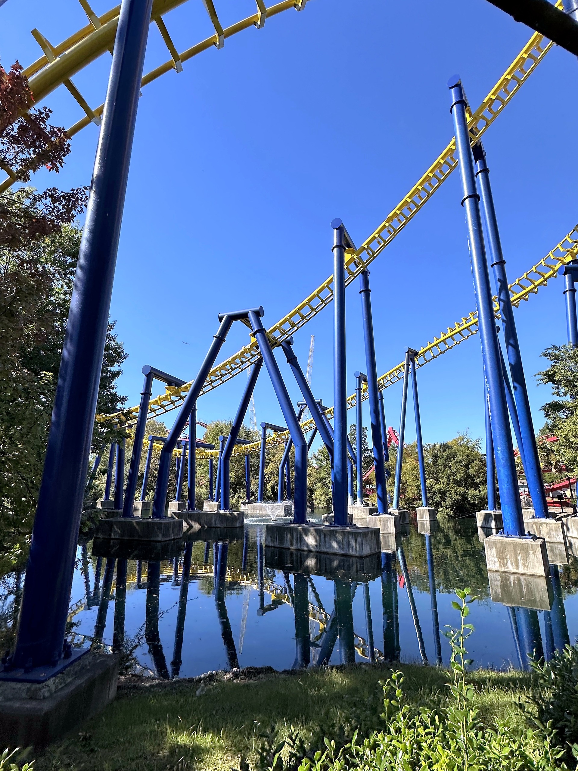 Nighthawk's supports and yellow track reflected in the pond at Carowinds, October 2024