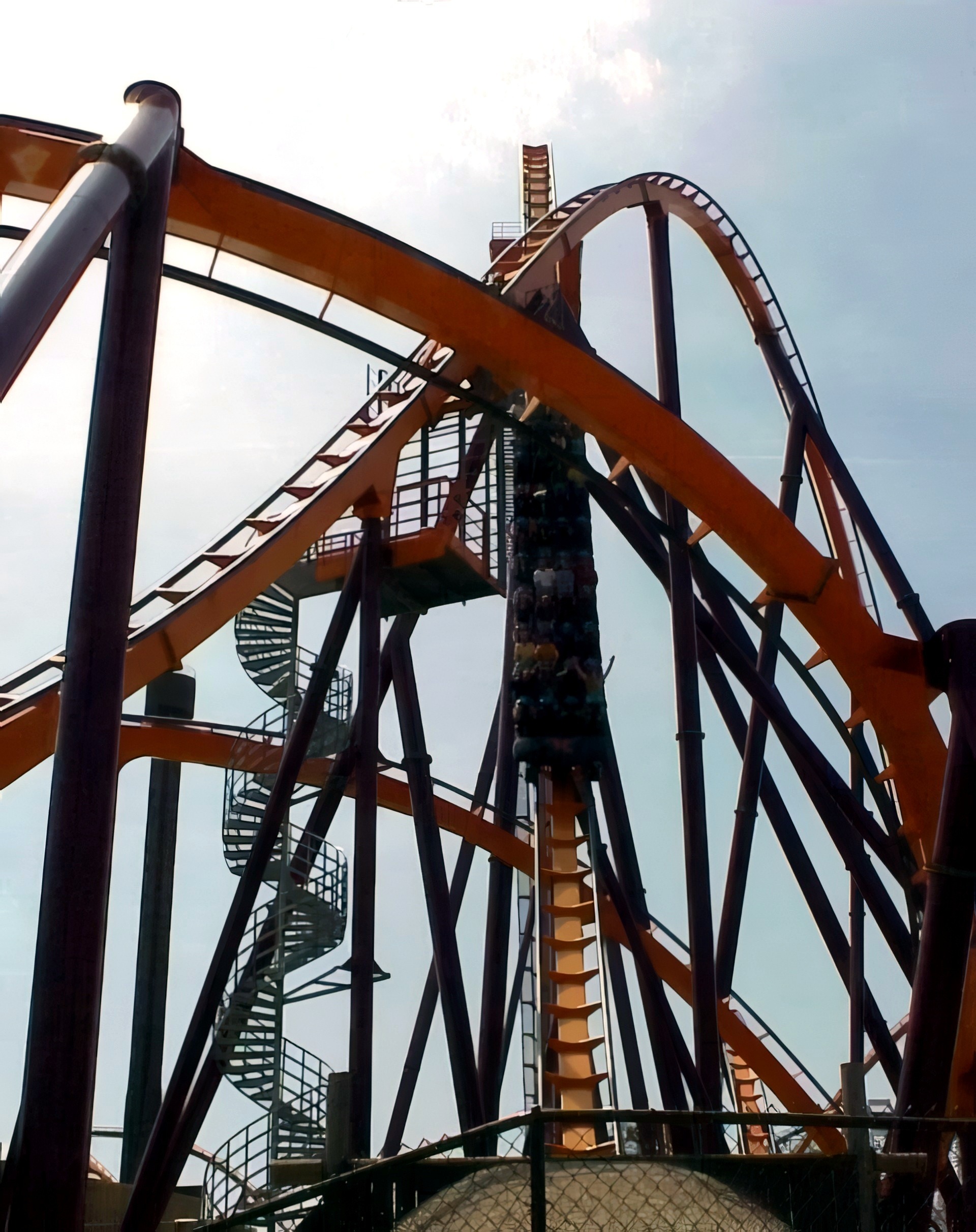 A Raging Bull train plunging down the first drop beside the spiral stairs at Six Flags Great America, 2000