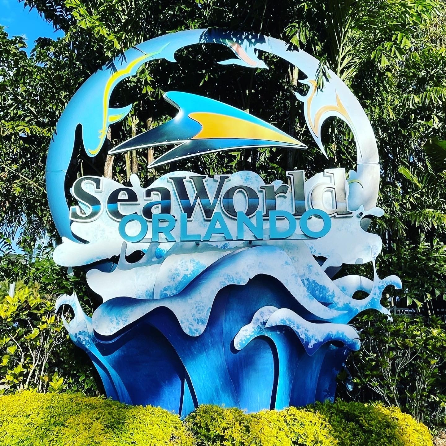 The SeaWorld Orlando entrance sign with its wave sculpture and orca and dolphin silhouettes at SeaWorld Orlando, March 2021