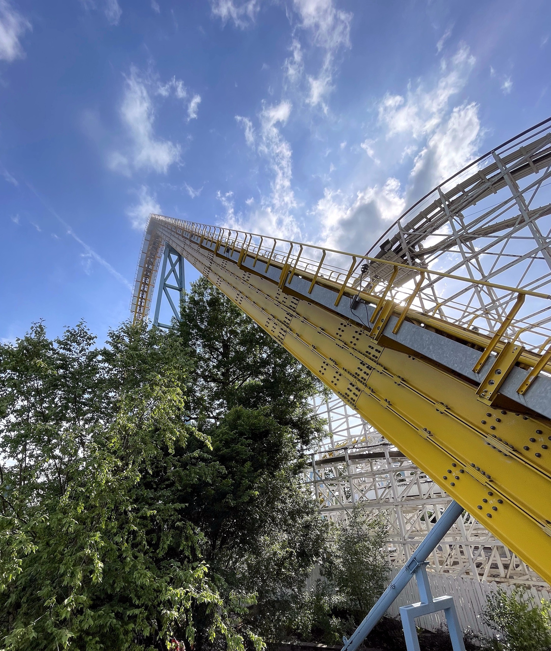 Skyrush's yellow lift hill above Comet's white wooden structure at Hersheypark, June 2021
