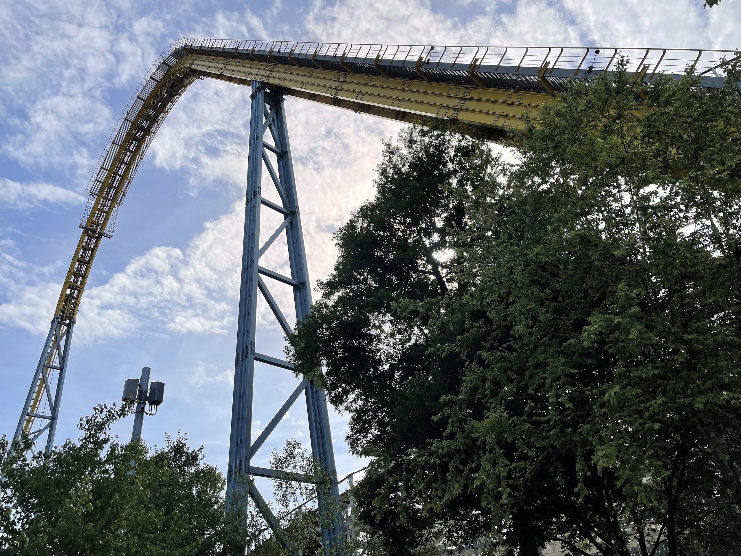 The crest of Skyrush's lift hill and the drop against a blue sky at Hersheypark, June 2021