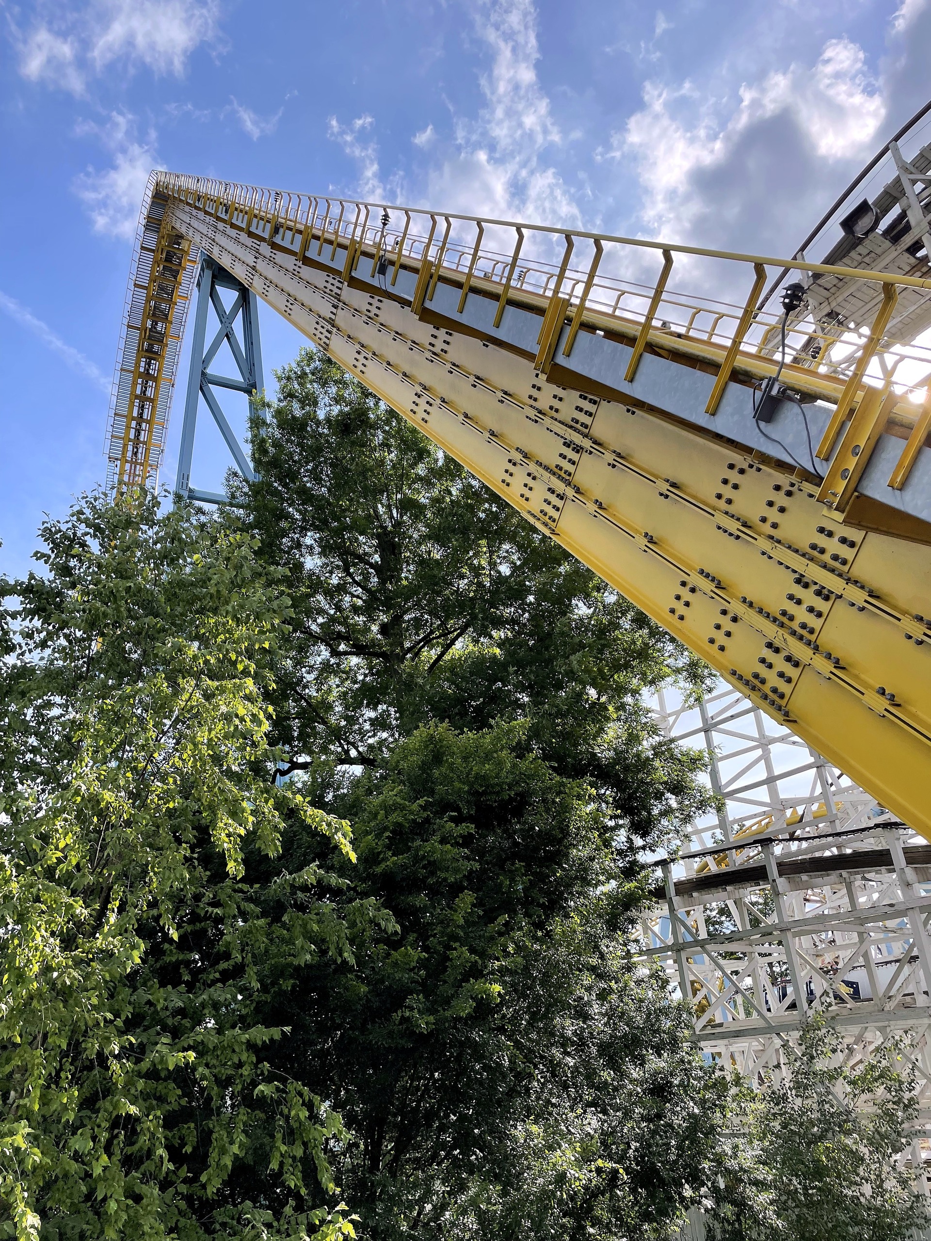 Skyrush's yellow lift hill rising from its base at Hersheypark, June 2021