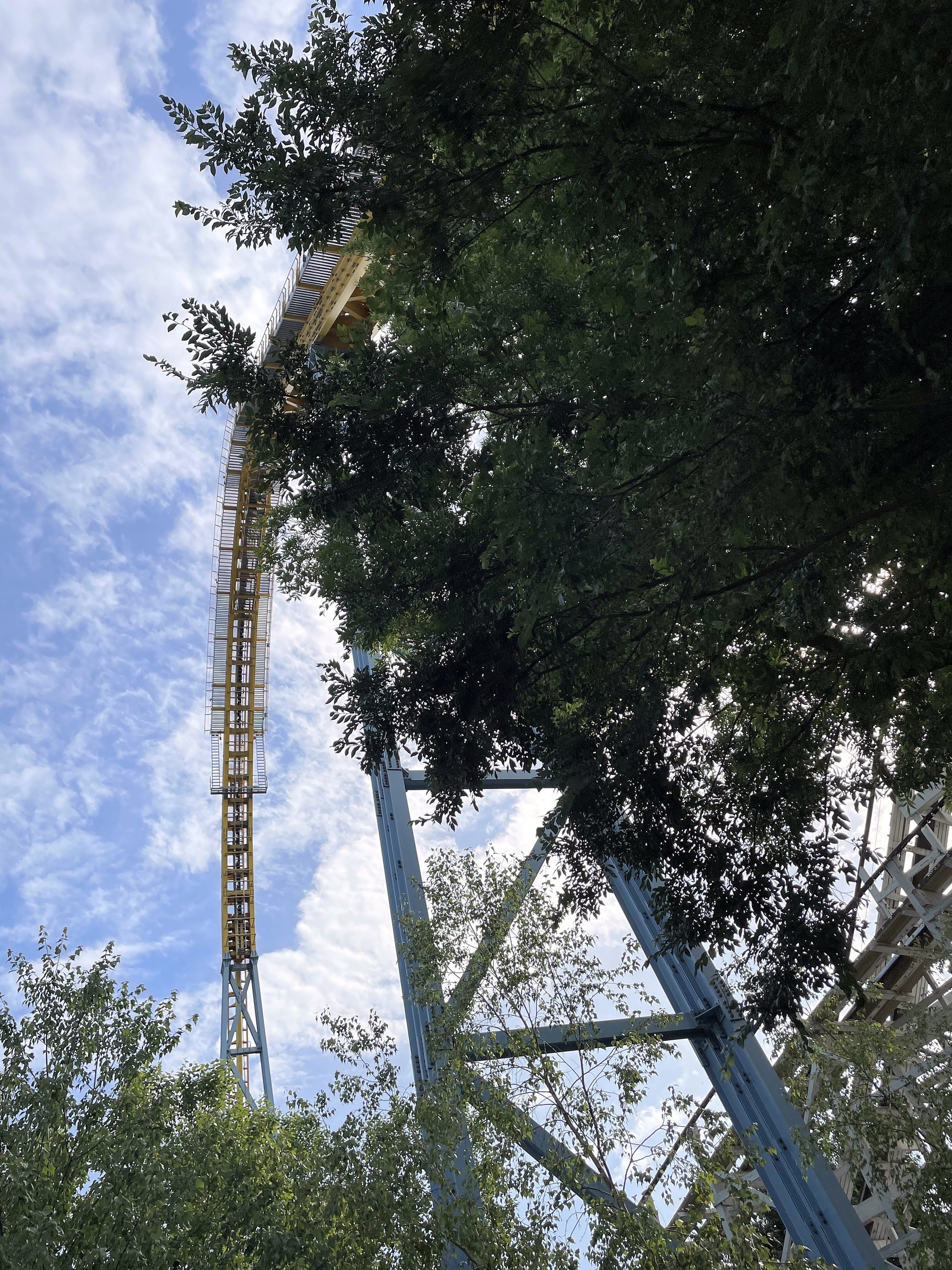 The top of Skyrush's lift hill above the trees at Hersheypark, June 2021