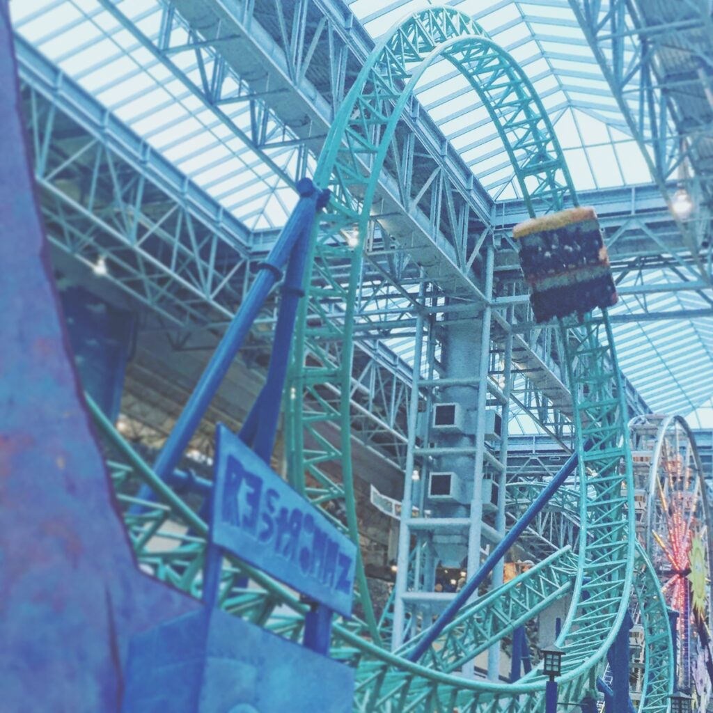 A Rock Bottom Plunge train on the teal track above the ride sign and the Ferris wheel, Nickelodeon Universe, November 2015