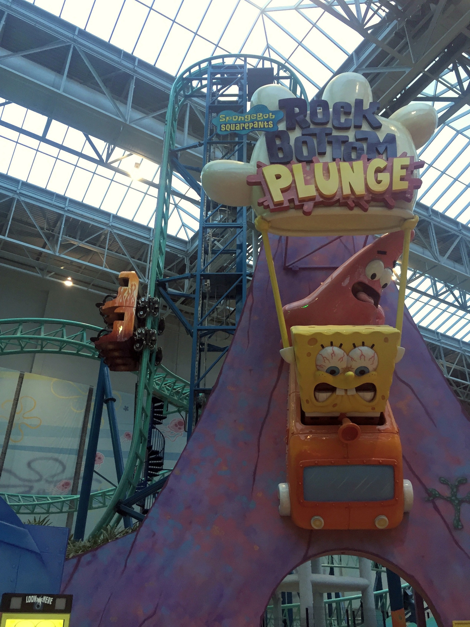 The SpongeBob SquarePants Rock Bottom Plunge sign with Patrick holding a SpongeBob cart at the entrance at Nickelodeon Universe, November 2015