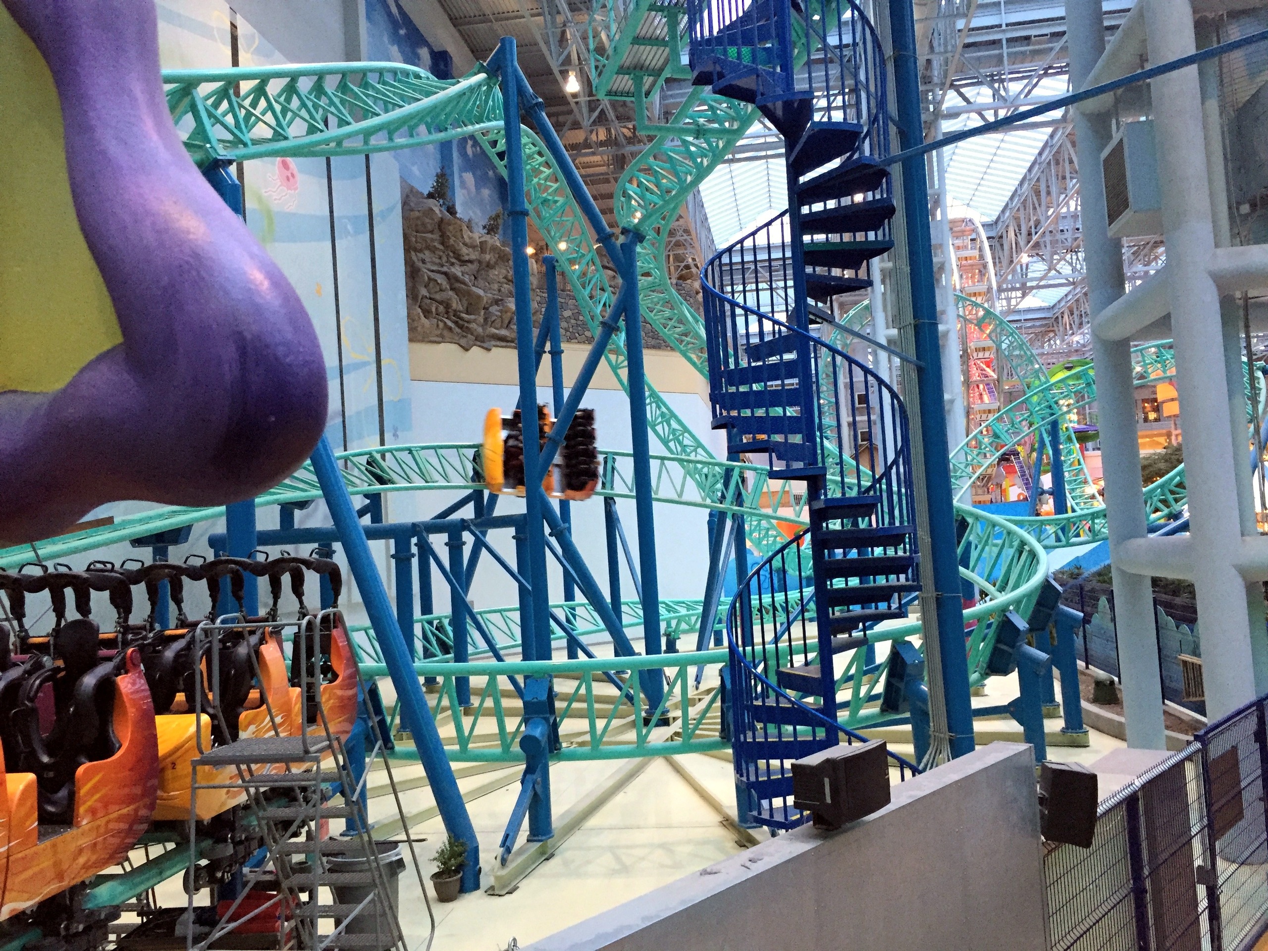 A SpongeBob SquarePants Rock Bottom Plunge train in the station with the spiral stairs and track beyond at Nickelodeon Universe, November 2015