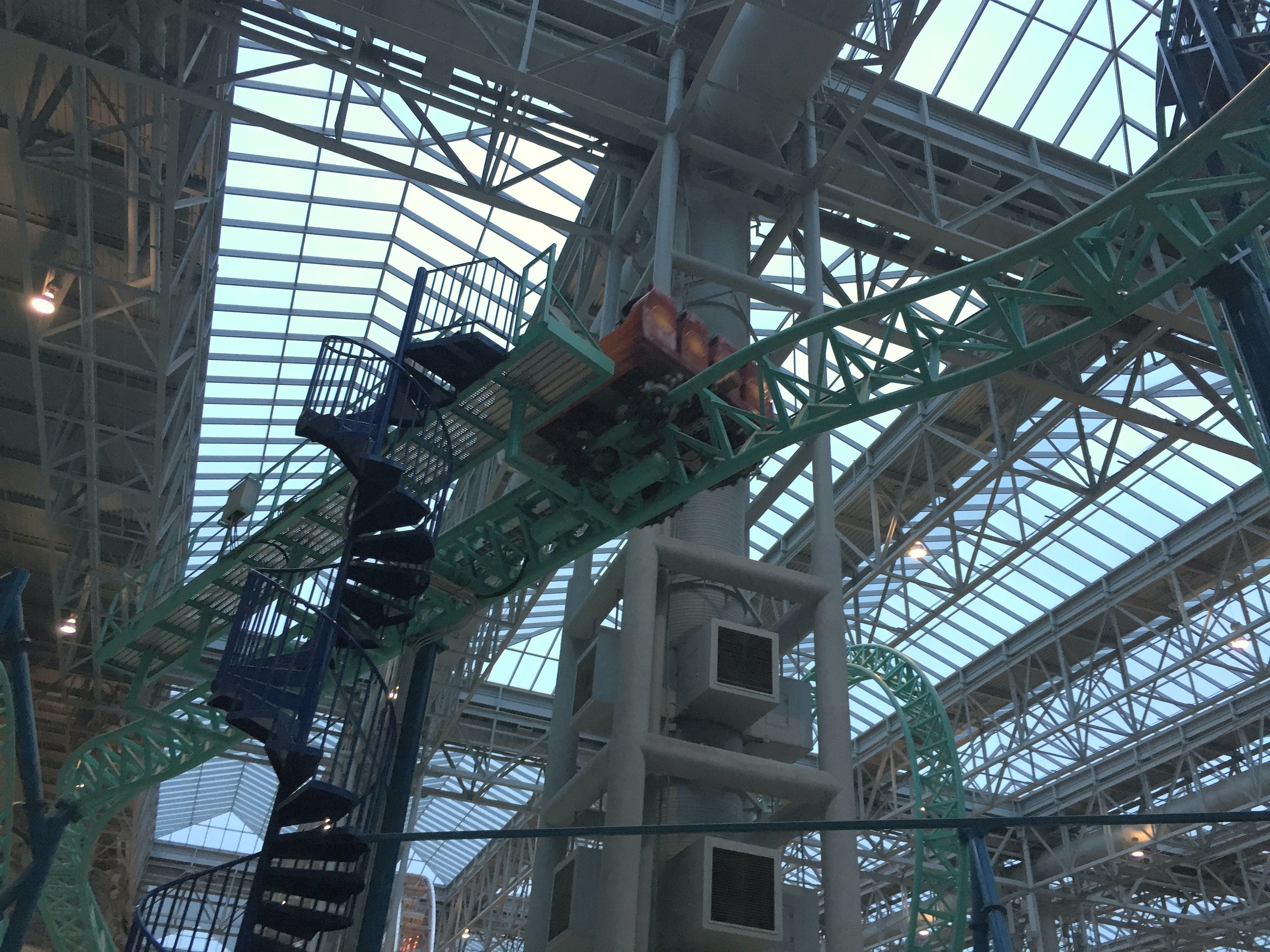 A SpongeBob SquarePants Rock Bottom Plunge car on the teal track beside the spiral stairs under the skylight roof at Nickelodeon Universe, November 2015
