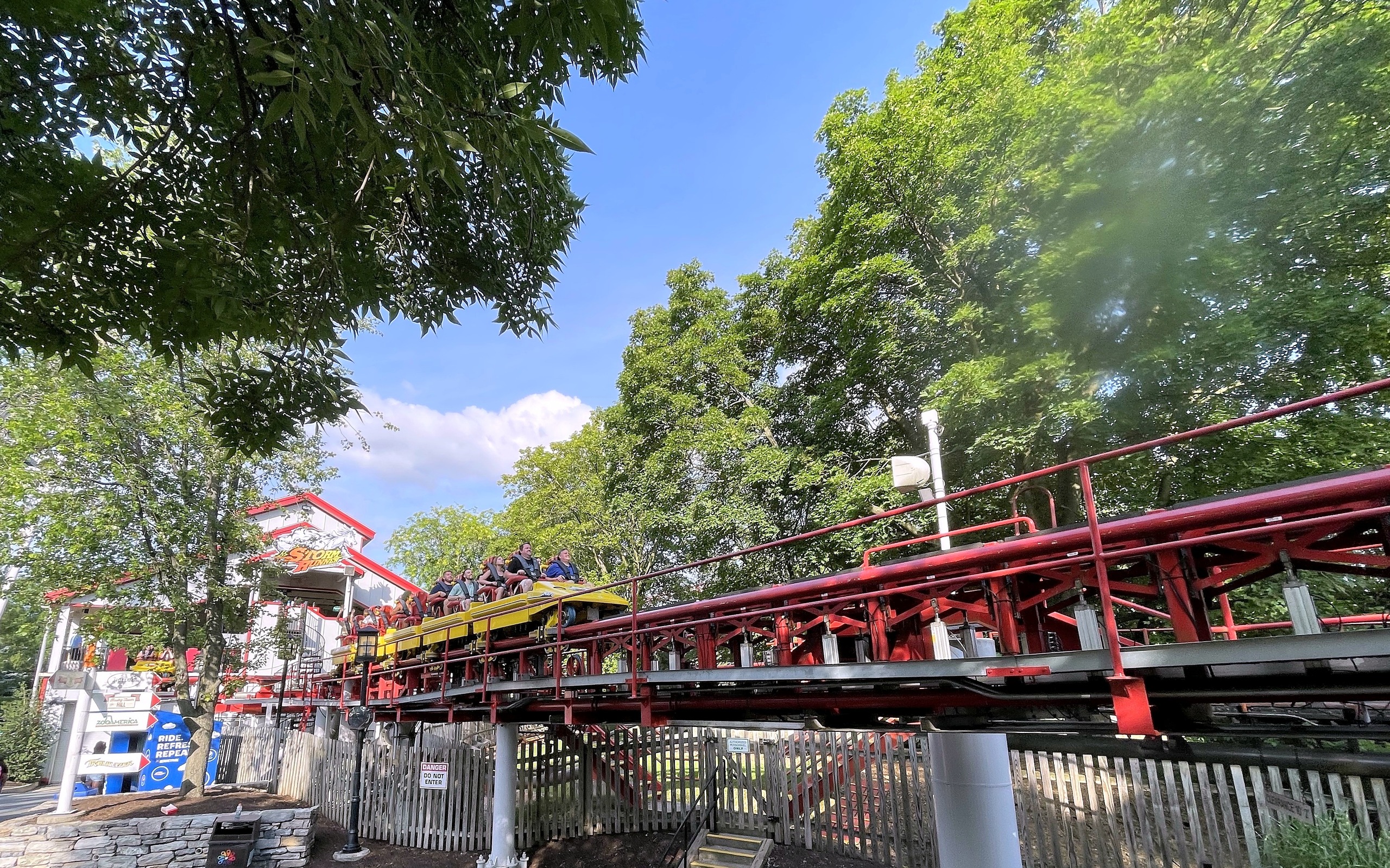 A Storm Runner train on the red launch track beside the station at Hersheypark, June 2021