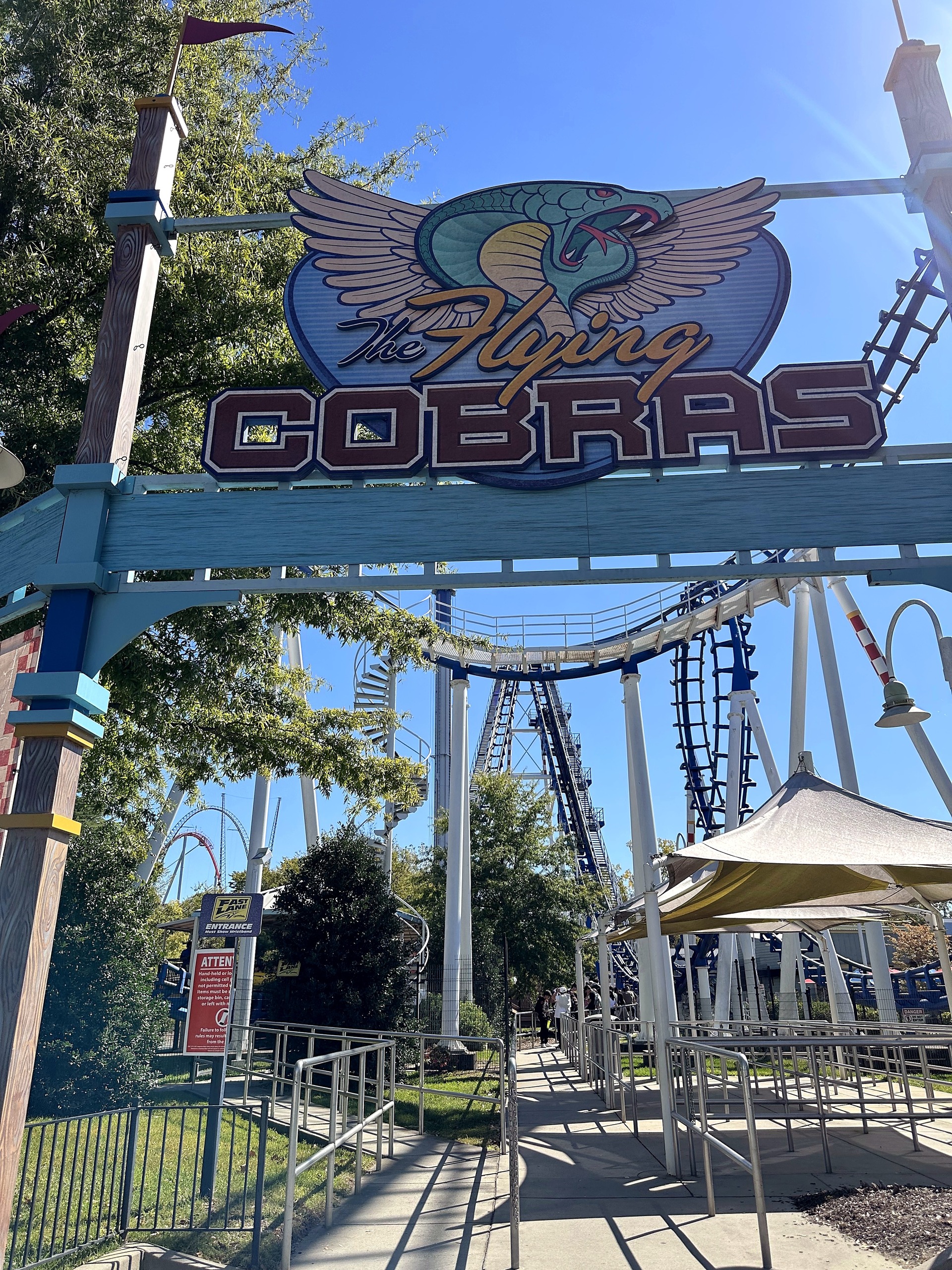 The Flying Cobras entrance arch with the winged cobra logo and the track behind at Carowinds, October 2024