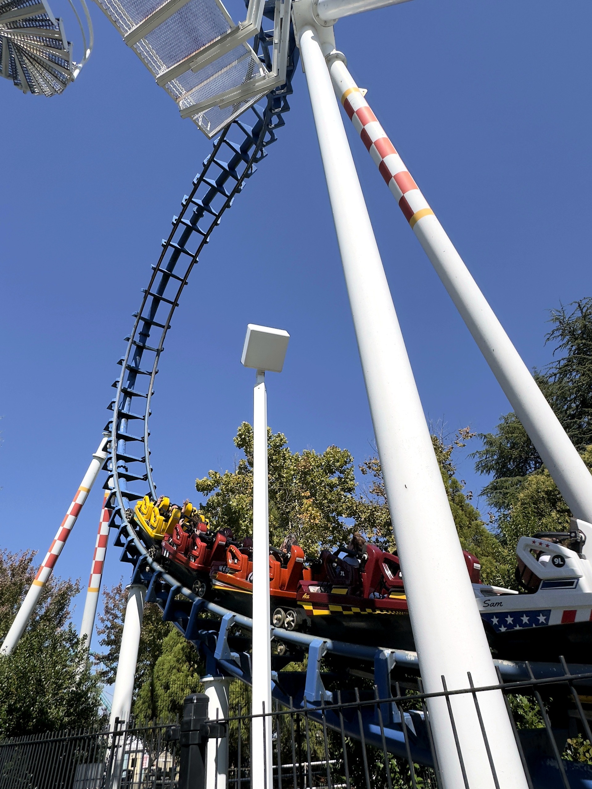 A Flying Cobras train starting out of the station below the loop at Carowinds, October 2024