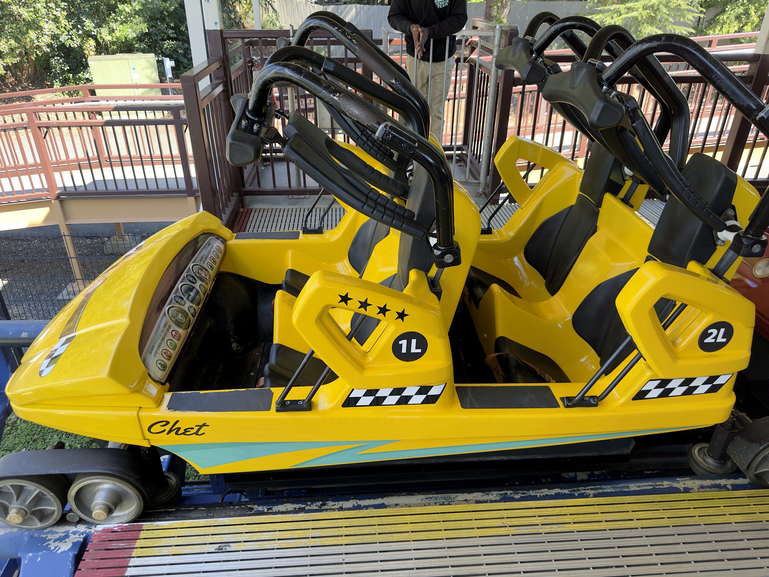 A yellow Flying Cobras car named Chet with checkered trim in the station at Carowinds, October 2024