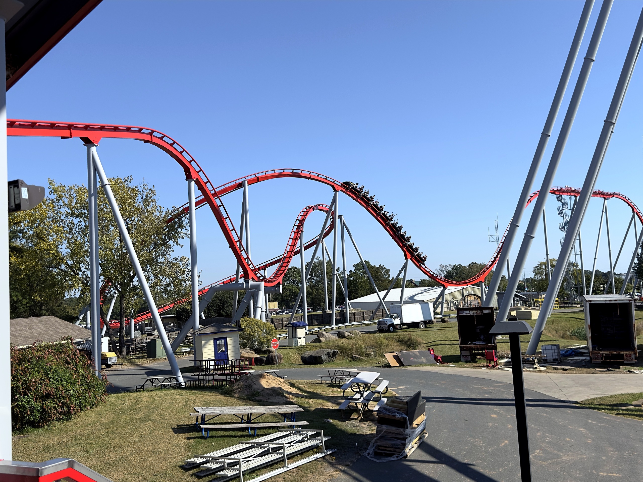 A Thunder Striker train on the red hills seen from the station area at Carowinds, October 2024