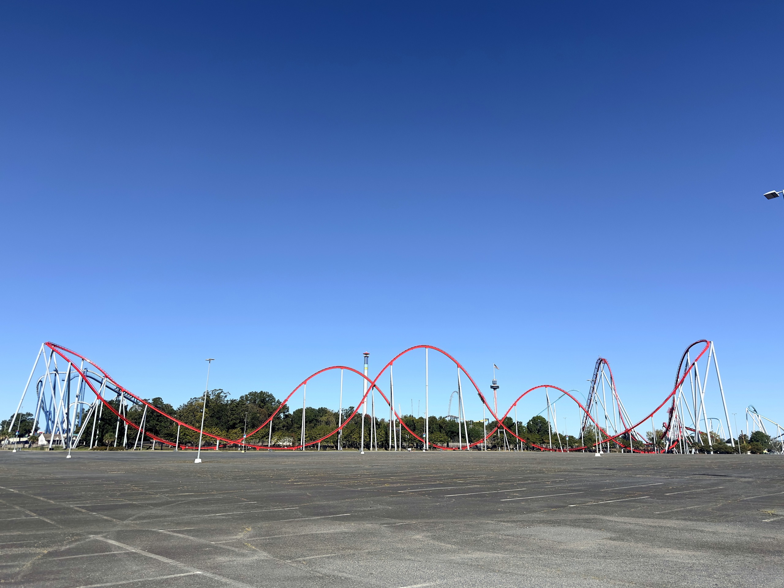 Thunder Striker's red track and airtime hills across the empty parking lot at Carowinds, October 2024