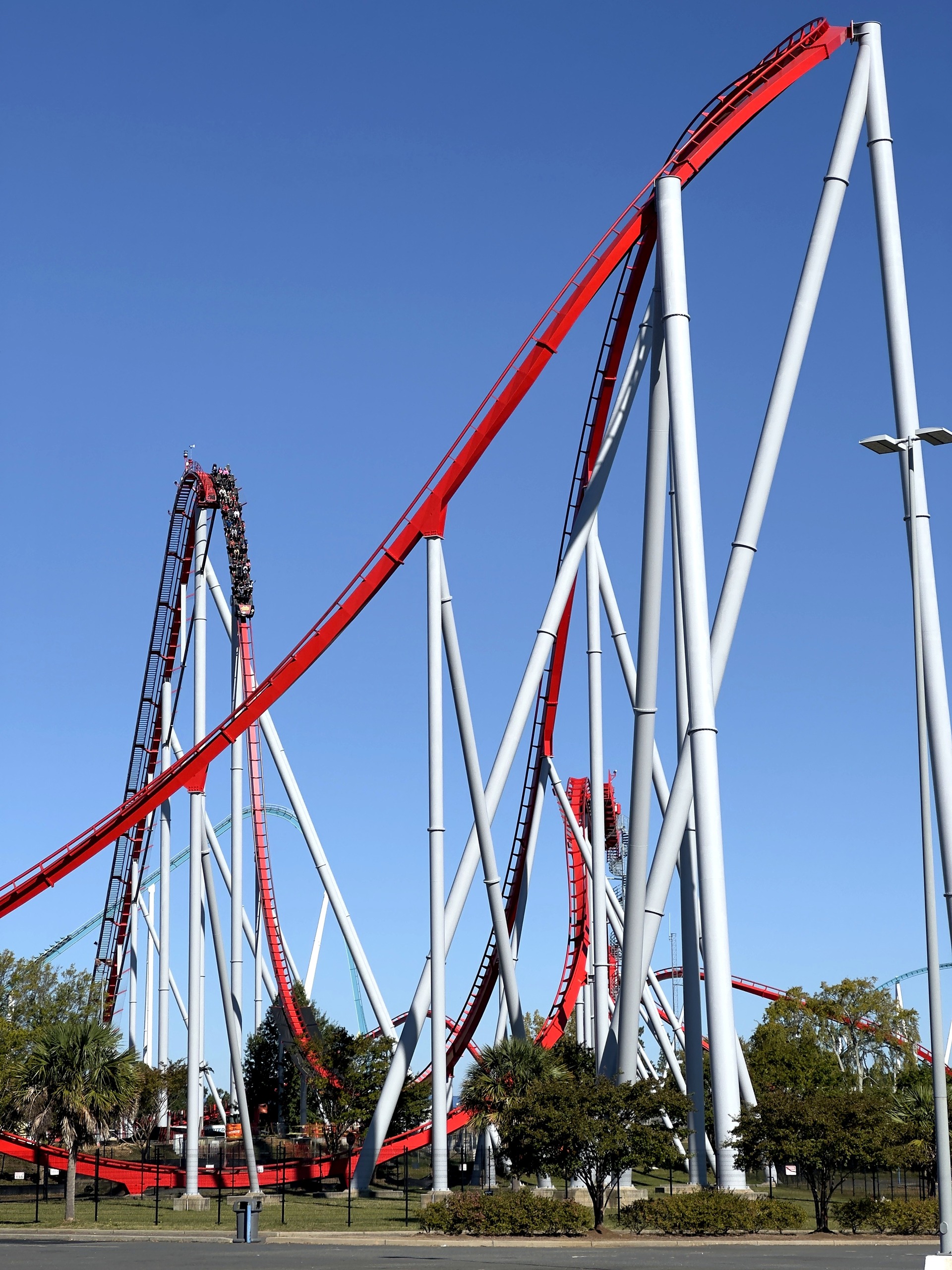 A Thunder Striker train on the first drop beside the lift hill, seen from the parking lot at Carowinds, October 2024