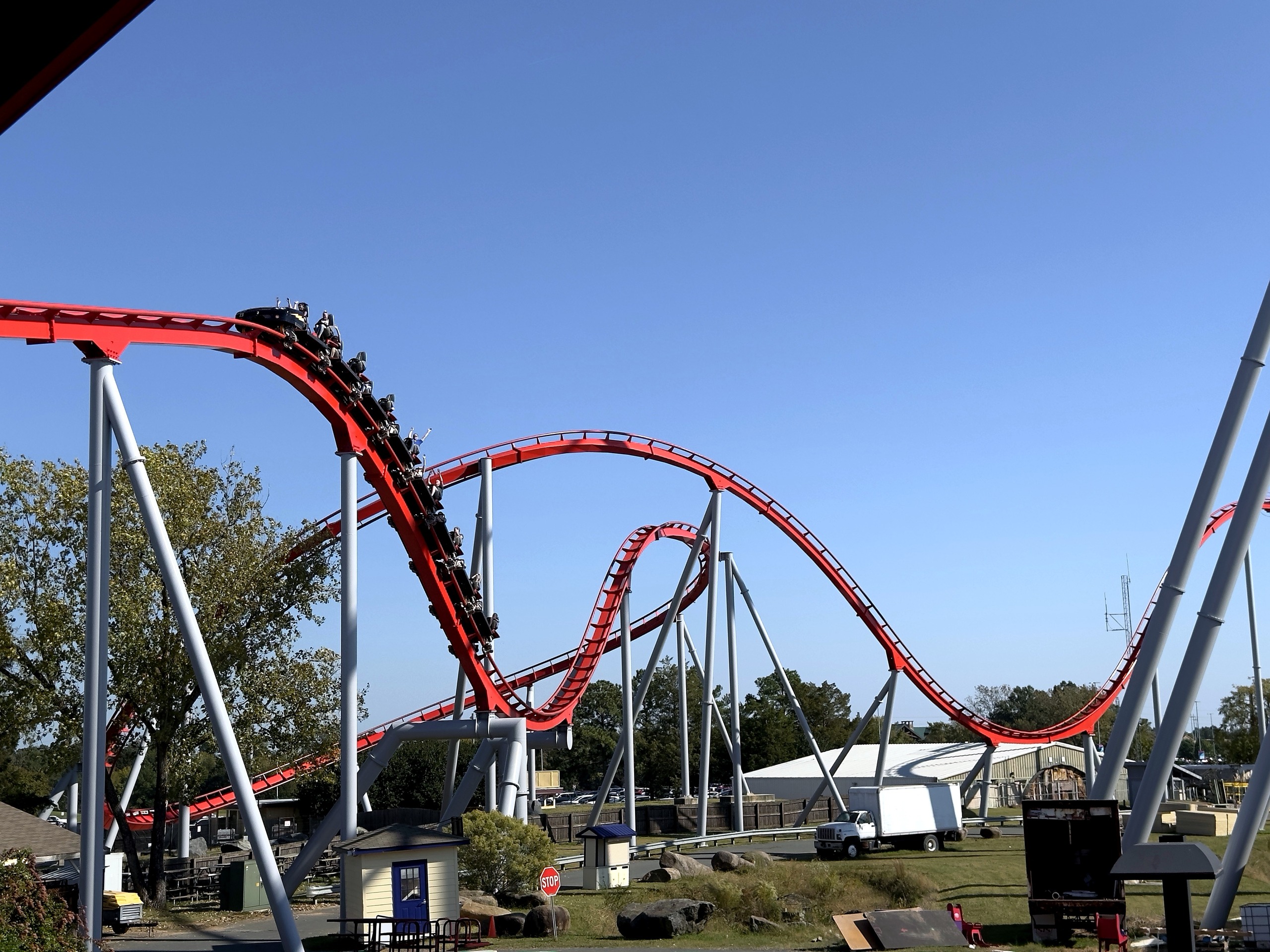 A Thunder Striker train diving down a red hill at Carowinds, October 2024