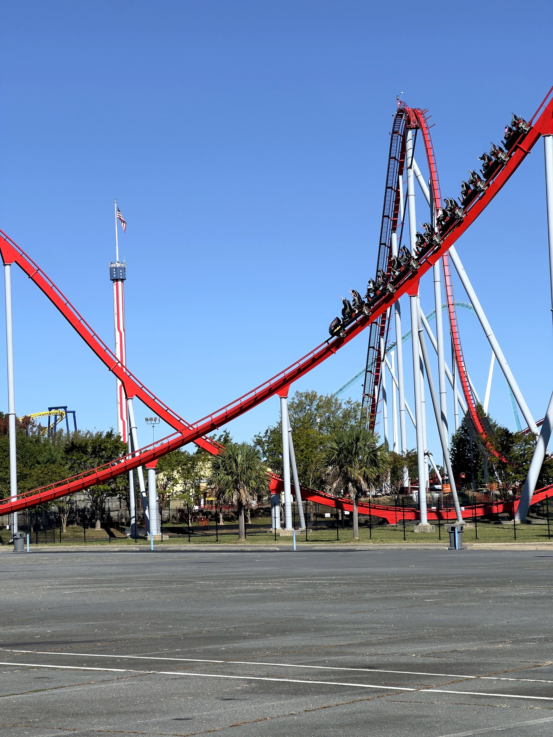 A Thunder Striker train on a red hill with the observation tower behind at Carowinds, October 2024