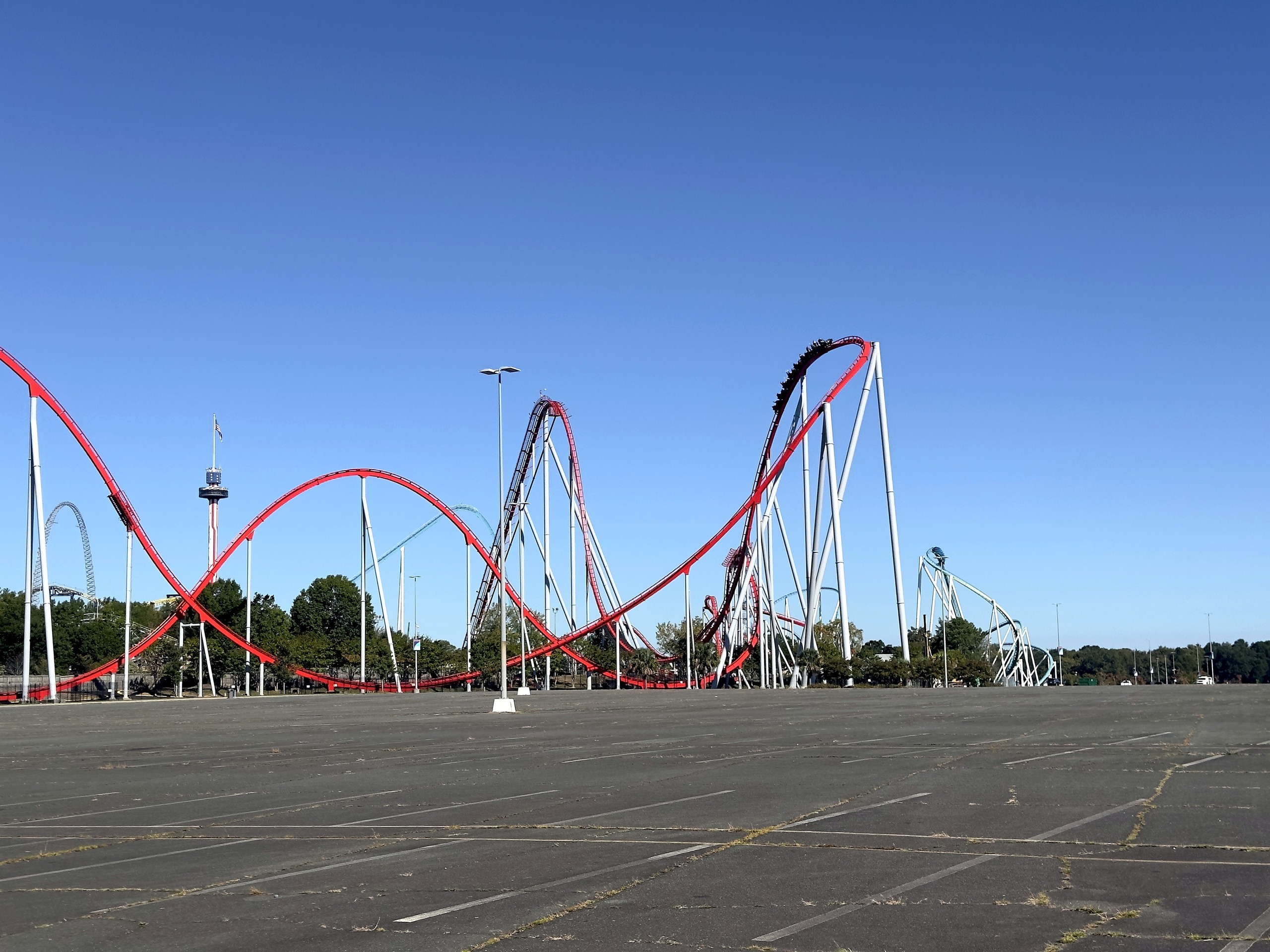 A Thunder Striker train at the top of the lift hill above the parking lot at Carowinds, October 2024