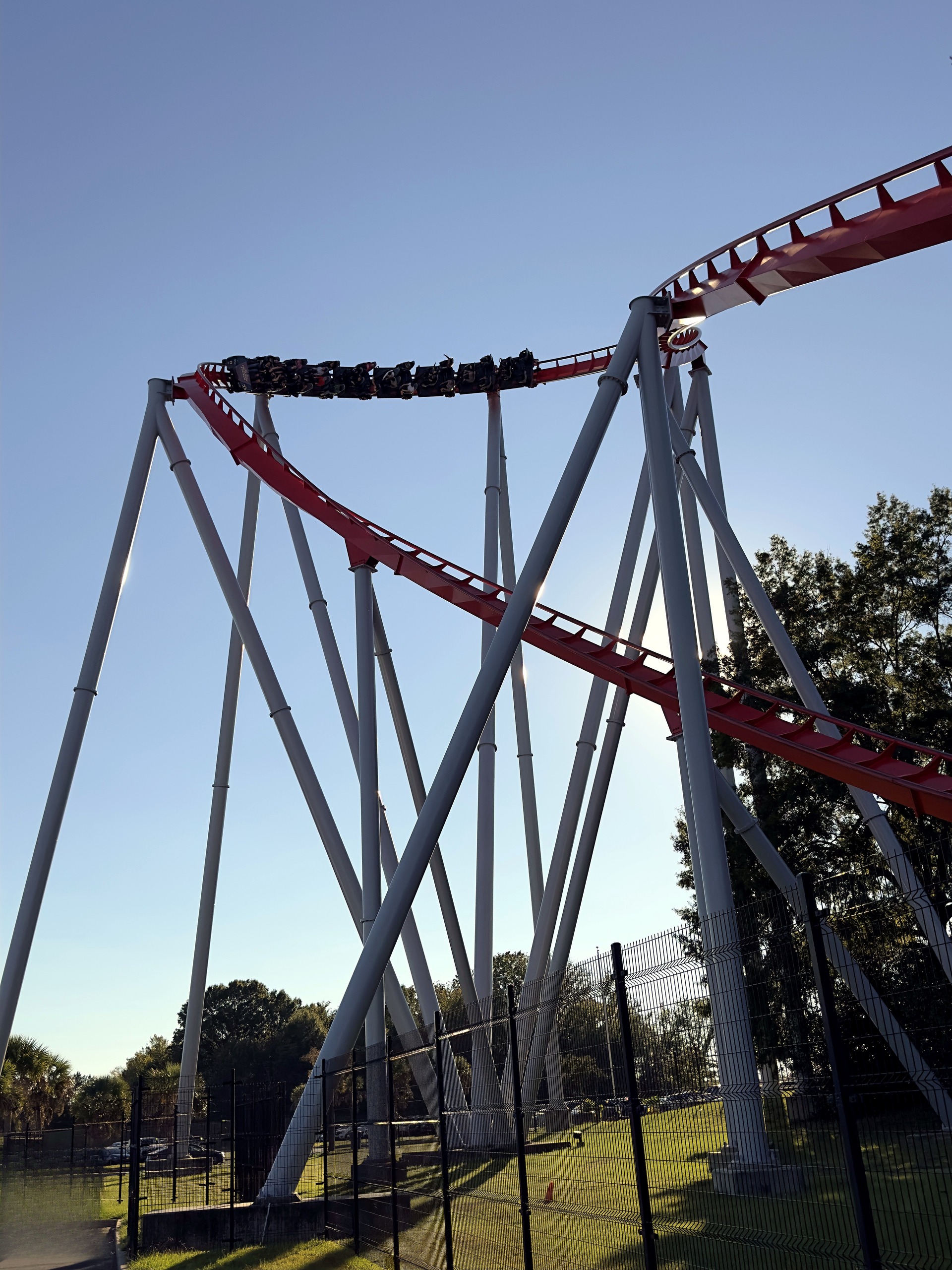 A Thunder Striker train on a turn above the gray supports in late-afternoon light at Carowinds, October 2024