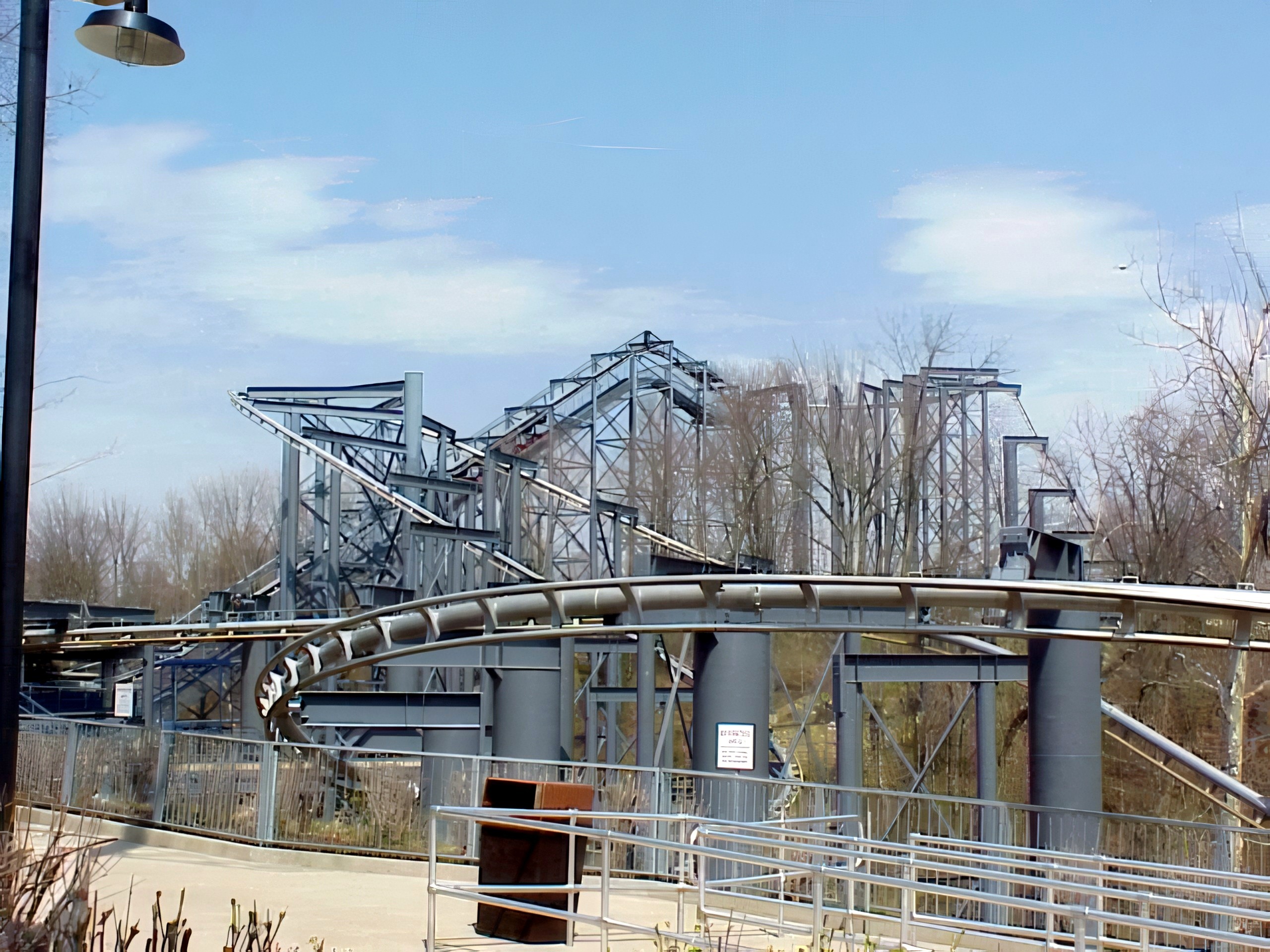 Top Gun's gray supports and track curving above the queue at Paramount's Kings Island, April 2001