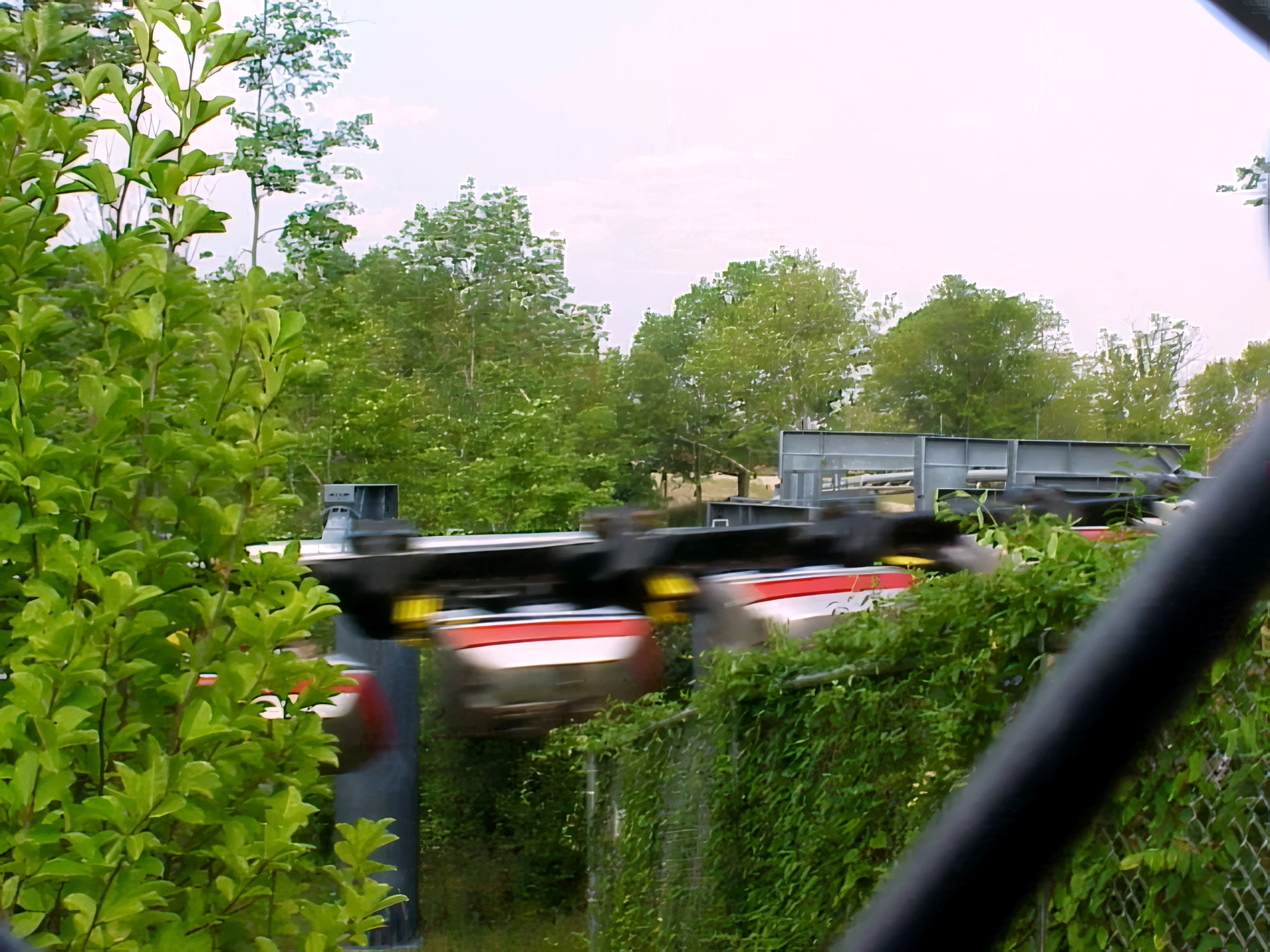 A Top Gun train swinging past the fence, blurred with speed at Paramount's Kings Island, August 2000